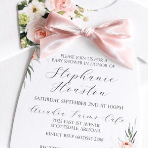 May include: Blush floral baby shower theme for girls invitation with pink ribbon and floral design. The invitation says "Please join us for a baby shower in honour of Stephanie Houston" and includes the date, time, location, and RSVP information. The invitation also includes the text "Registered at Target & Amazon".