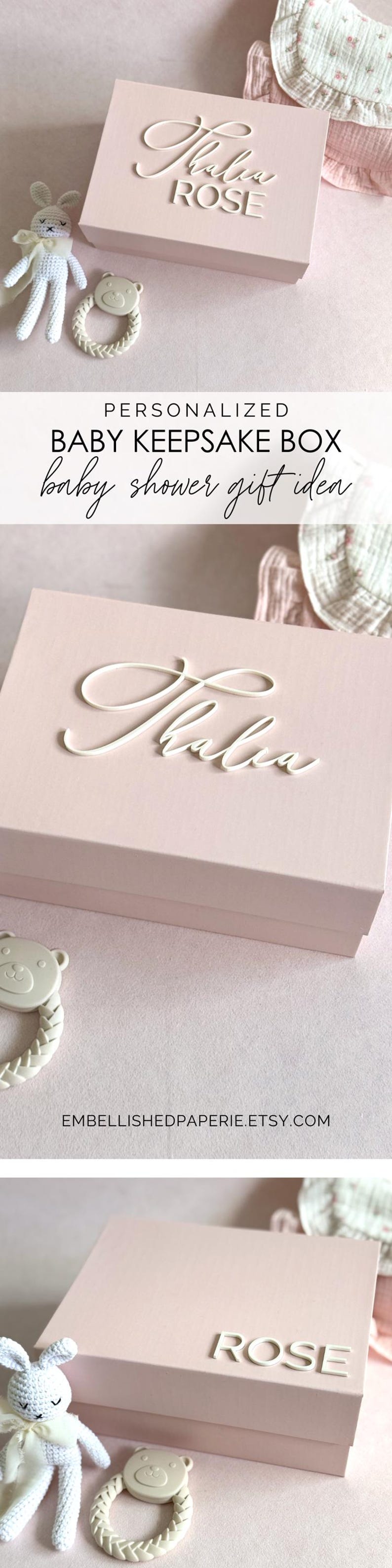 May include: A light pink baby keepsake box with the name "Thalia Rose" in white script. The box is next to a white crochet bunny and a bear-shaped teether. The image also includes text that says "Baby Keepsake Box" and "Baby Shower Gift Idea".
