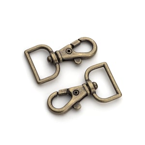 May include: Two antique gold-toned metal swivel clasps with a rectangular loop and a spring-loaded gate.