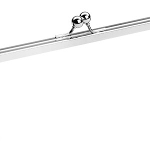 May include: A silver-toned purse frame with two round metal clasps. The frame is designed to be used for a clutch or handbag.
