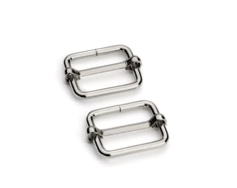 May include: Two silver metal slider buckles. The buckles are rectangular with rounded corners and have a smooth, polished finish.