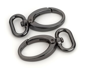 May include: Two black metal swivel clasps with oval rings. The clasps are closed and ready to be attached to a bag or other item.
