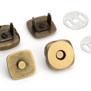 May include: Four antique gold magnetic snaps with two silver metal plates. The snaps are square and have a raised center. The plates are round with two slots.