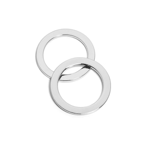 May include: Two silver metal rings, one slightly larger than the other, are interlocked.