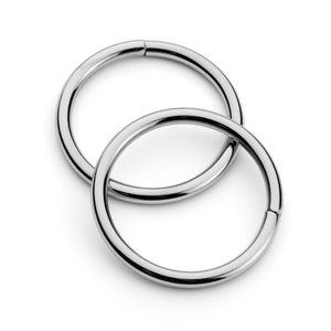 May include: Two silver metal rings, one slightly larger than the other, are interlocked. The rings are smooth and shiny.