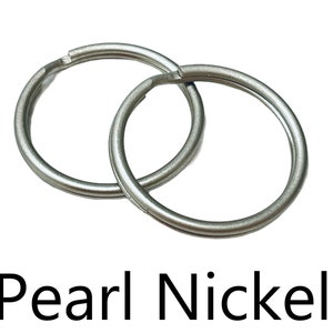 May include: Two interlocking silver key rings in a pearl nickel finish.