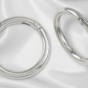 May include: Two silver metal rings with a hinged opening. The rings are smooth and shiny.
