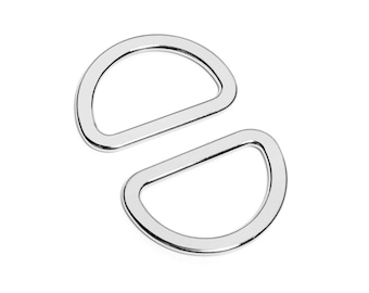May include: Two silver D-rings, a common hardware item used for attaching straps, belts, or other accessories.