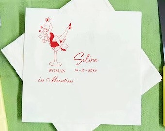 May include: White cocktail napkin with a red illustration of a woman in a martini glass. The napkin has the name "Selina", the date "10-10-2030", and the words "WOMAN in Martini" printed in red.