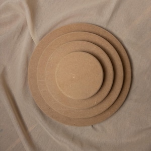Könnte beinhalten: Ein Set aus drei Keramikbechern mit gesprenkelter, matter Oberfläche. Die Becher sind in den Farbtönen Creme, Hellgrau und Dunkelgrau gehalten. Jeder Becher hat ein schlichtes, minimalistisches Design und einen abgerundeten Henkel.