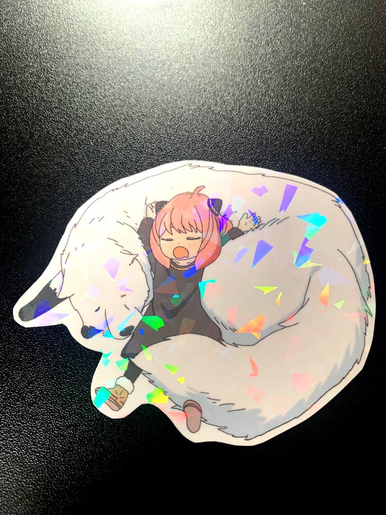 May include: A holographic sticker featuring a pink-haired anime character sleeping on a white wolf. The sticker has a sparkly, iridescent finish.