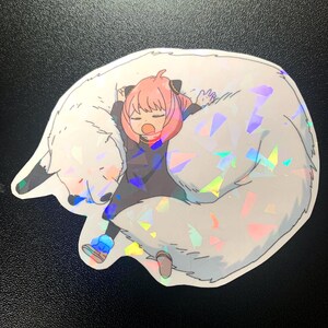 May include: A sticker featuring a cartoon girl with pink hair sleeping on a white furry animal with iridescent glitter. The girl is wearing a black shirt and blue trousers.