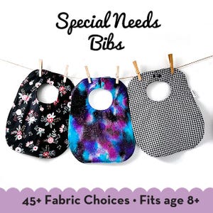 May include: Three different fabric bibs hanging on a clothesline. The bibs are black with white flowers, blue with purple and white galaxy print, and black and white houndstooth. The text "Special Needs Bibs" is at the top of the image. The text "45+ Fabric Choices. Fits age 8+" is at the bottom of the image.