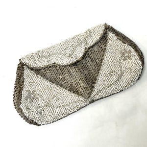 Op de afbeelding: Een witte parelclutch met een geometrisch ontwerp. De clutch heeft een klep sluiting en is gemaakt van kleine, witte parels.