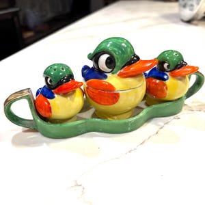 Può includere: Un set di tre tazze in ceramica con finitura opaca e macchiettata. Le tazze sono nei toni del crema, grigio chiaro e grigio scuro. Ogni tazza ha un design semplice e minimalista e un manico arrotondato.