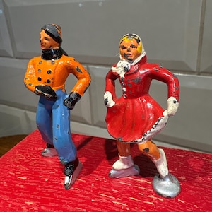 Par de patinadores sobre hielo de plomo de metal fundido Barclay, decoración navideña e invernal de los años 40