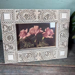 Postal vintage enmarcada, marco de resina color hueso con rosa dimensional y detalle enrejado, ilustración de ramo de rosas rosadas de los años 30-40.