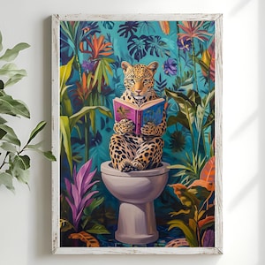 May include: A framed art print shows a leopard reading a book on a toilet, set against a backdrop of a vibrant jungle. The artwork features lush green foliage and colorful flowers. The leopard has a spotted coat and is holding a book with a pink cover.