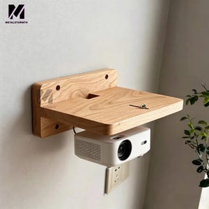 May include: A wooden projector shelf mounted on a wall. The shelf is made of light-colored wood and has a square platform with a cutout. A white projector is mounted below the shelf. The brand name "METALSTORMTH" is visible.