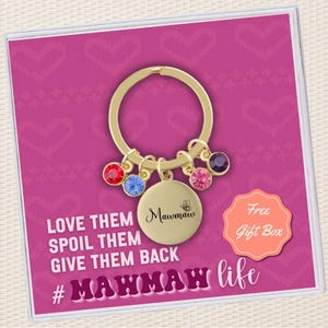 May include: Gold keychain with a round charm that says "Mawmaw" and a butterfly design. The keychain has five colorful crystals attached to it. The text "Love them, spoil them, give them back #Mawmaw life" is written below the keychain. A peach-colored box with the text "Free Gift Box" is in the upper right corner of the image.