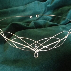 Puede incluir: Diadema de alambre plateado con un dise&ntilde;o delicado e entrelazado. La diadema est&aacute; adornada con peque&ntilde;as cuentas redondas.