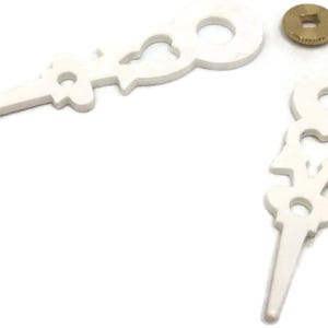 May include: A pair of white plastic clock hands with a decorative design. The hands are designed to fit a clock with a standard size shaft.