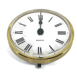 May include: A gold-rimmed clock face with Roman numeral hour markers and a black quartz movement. The clock face is white with black hands.