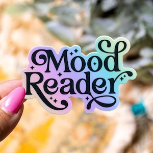 May include: A holographic sticker with a rainbow gradient background and black text that reads "Mood Reader".