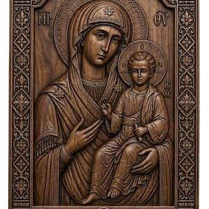 Puede incluir: Icono religioso de madera tallada que representa a la Virgen María con el Niño Jesús. El icono está enmarcado con diseños ornamentales de flores y cruces. Las figuras están en relieve, con halos e inscripciones. La madera tiene un tono marrón cálido.
