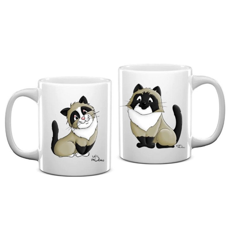 May include: Two white ceramic mugs with black handles. Each mug features a cartoon illustration of a cat with black and white markings. The cat on the left mug is looking to the right, while the cat on the right mug is looking to the left.