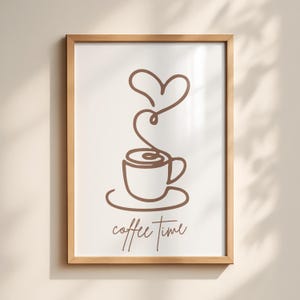 Può includere: Una stampa incorniciata con un disegno a tratto minimalista di una tazza di caffè, con vapore a forma di cuore. Le parole "coffee time" sono scritte sotto in un carattere script. La cornice è in legno marrone chiaro.