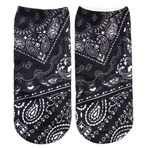 May include: A pair of black ankle socks with a white paisley pattern. The socks are made of a soft, comfortable material and are perfect for everyday wear.