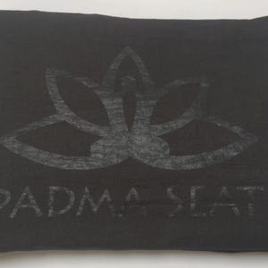 May include: Black meditation cushion with a lotus flower design and the text "PADMA SEAT" printed on the front.