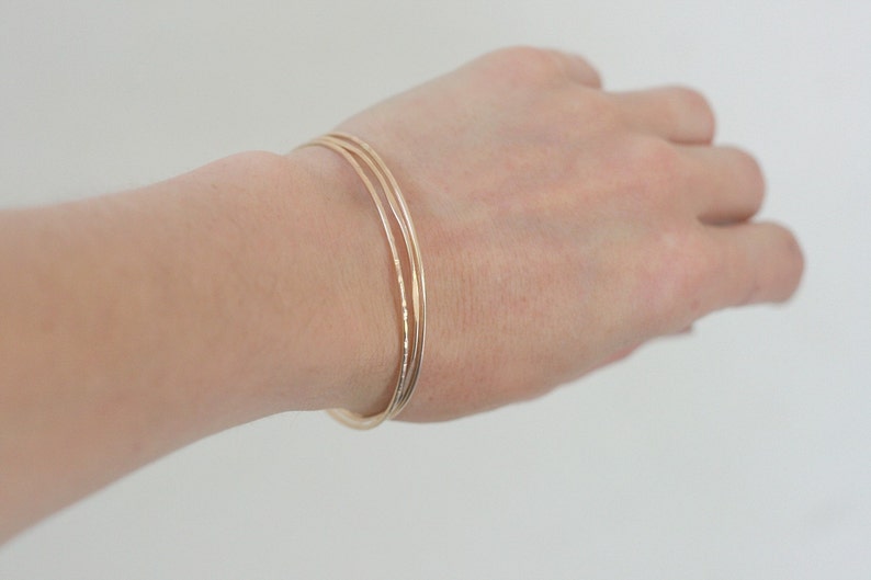 bracciale impilabile in oro. set di tre braccialetti. Braccialetti in filo martellato riempiti d'oro 14k. braccialetto sottile. immagine 8