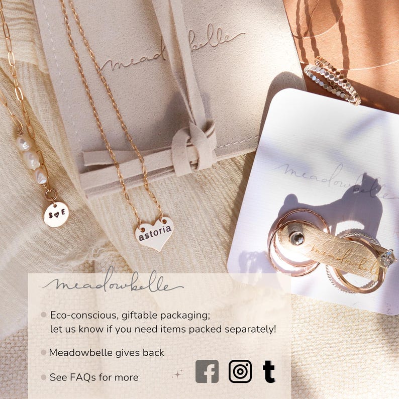 Gift packaging and branding samples for Meadowbelle jewelry are shown flat lay style featuring a jewelry pouch. Also shown are a pearl bracelet and a custom engraved heart name necklace. A stack of mixed metal rings and a gemstone ring are on a business card with a little reusable jewelry holder. The image description mentions Meadowbelle values such as philanthropic efforts, giving back to the community and eco-consciousness. Social media channels are featured for Facebook, Instagram and TikTok