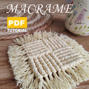 May include: A close-up of a beige macrame coaster with fringe. The coaster is made with a knotting technique and has a square shape. The text "MACRAME PDF TUTORIAL" is visible in the image.