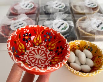 May include: A set of small, hand-painted ceramic bowls with colorful floral designs. The bowls are perfect for serving small snacks or treats.