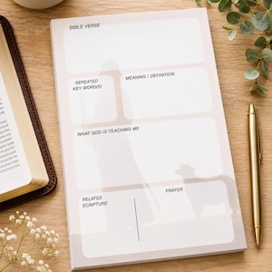 K&ouml;nnte beinhalten: Ein Notizblock f&uuml;r das Bibelstudium mit Abschnitten f&uuml;r "Bibelvers", "Wiederholtes Schl&uuml;sselwort(e)" und "Gebet". Der Notizblock hat einen hellbeigen Hintergrund mit einer Schafillustration. Ein goldener Stift liegt daneben.