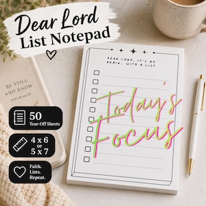 May include: A white notepad with the text "Dear Lord List Notepad" and "Today's Focus" in a script font. The notepad has a list format with check boxes and includes 50 tear-off sheets. A pen and a book are also in the image.