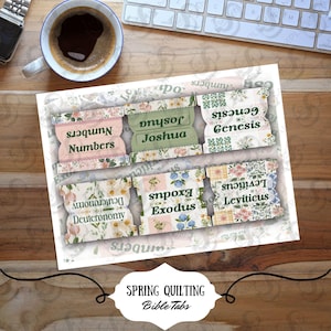 May include: A sheet of Bible tabs with floral patterns and text labels for each book. The tabs are in pastel colors and feature the titles of the books of the Bible. The image also includes a coffee cup, a watch, and a keyboard.
