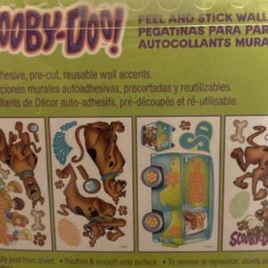 May include: A set of 6 Scooby-Doo peel and stick wall decals. The decals feature Scooby-Doo in various poses, including running, holding a magnifying glass, and riding in the Mystery Machine. The decals are self-adhesive, pre-cut, and reusable.