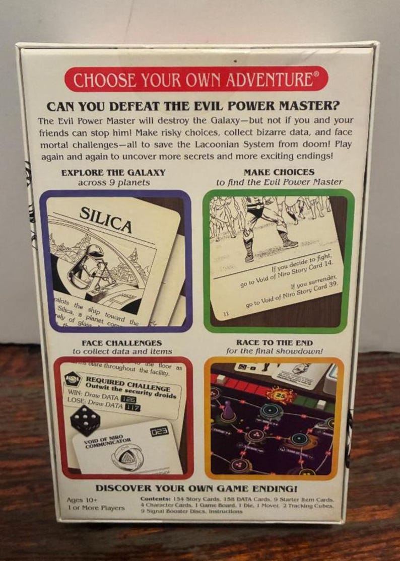 K&ouml;nnte beinhalten: Brettspielbox mit dem Titel "CHOOSE YOUR OWN ADVENTURE". Die Box zeigt Text und Illustrationen, darunter Karten mit der Aufschrift "SILICA" und "VOID OF NIRO COMMUNICATOR". Das Spiel verspricht Erkundung, Herausforderungen und verschiedene Enden.