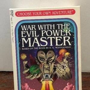 K&ouml;nnte beinhalten: Eine Vintage-Brettspielbox mit dem Titel "War With The Evil Power Master". Das Cover zeigt eine bedrohliche Alienfigur mit einer gr&uuml;nen Kugel, einer Rakete und dem Text "Choose Your Own Adventure".