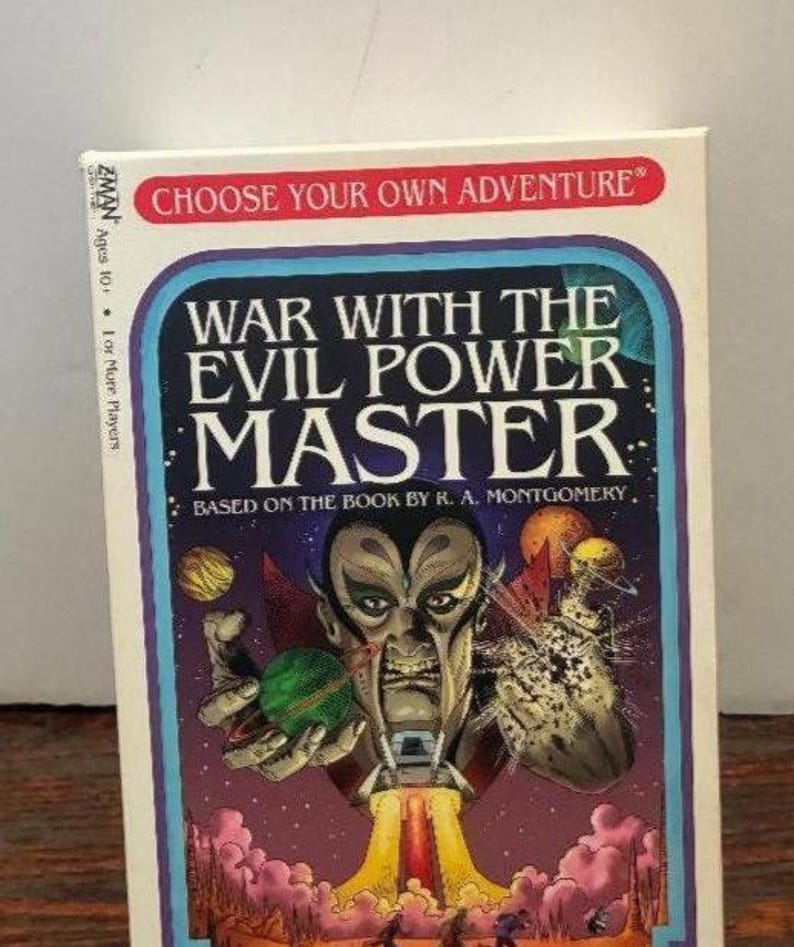 K&ouml;nnte beinhalten: Eine Vintage-Brettspielbox mit dem Titel "War With The Evil Power Master". Das Cover zeigt eine bedrohliche Alienfigur mit einer gr&uuml;nen Kugel, einer Rakete und dem Text "Choose Your Own Adventure".