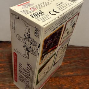 K&ouml;nnte beinhalten: Eine Brettspielbox mit dem Titel "War With The Evil Power Master" von Z-Man Games. Die Box ist wei&szlig; mit rotem und schwarzem Text und Illustrationen. Das Spiel ist f&uuml;r Spieler ab 10 Jahren und f&uuml;r mehr Spieler.