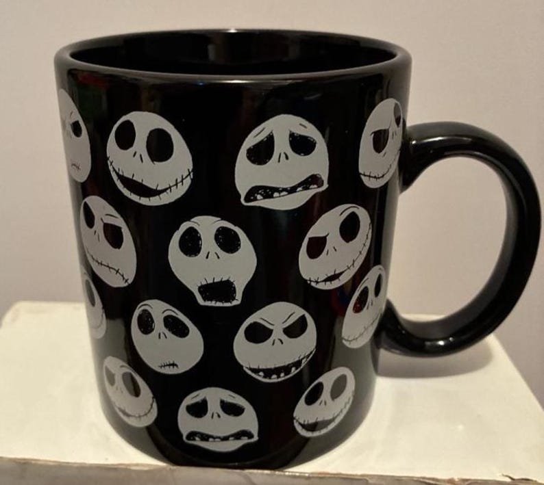 Puede incluir: Taza de cer&aacute;mica negra con m&uacute;ltiples caras blancas de Jack Skellington con diversas expresiones. La taza tiene un asa negra y es adecuada para bebidas fr&iacute;as o calientes. Un gran regalo para los fans de la pel&iacute;cula.