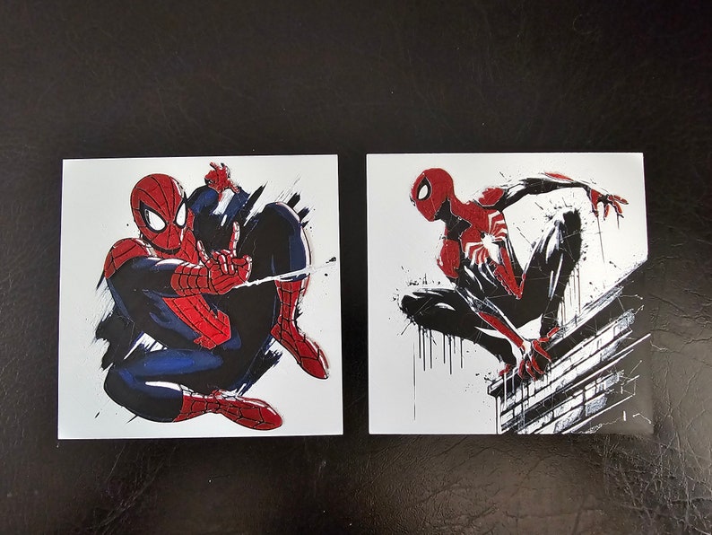 May include: Two illustrations of Spiderman in different poses. The first image shows Spiderman in a red and blue suit with a black background. The second image shows Spiderman in a red and black suit with a white background.
