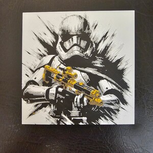 May include: A black and white illustration of a Stormtrooper from Star Wars holding a blaster rifle. The illustration is done in a stylised, almost abstract style, with a lot of white and black splatter paint.