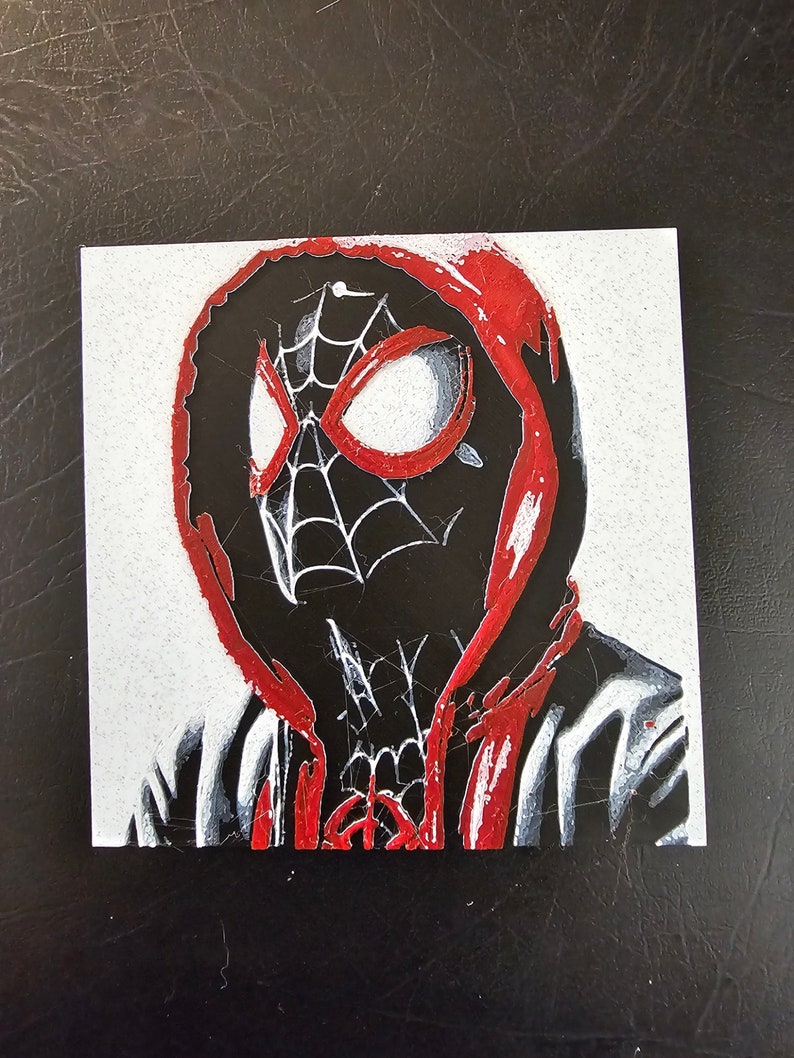 May include: An illustration of Spider-Man wearing a red hooded sweatshirt. The illustration is done in a stylised, almost pixelated style.