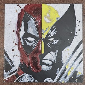Könnte beinhalten: Ein digitaler Kunstdruck eines geteilten Gesichtsbildes von Deadpool und Wolverine. Das Bild ist in Schwarz, Weiß, Rot und Gelb gehalten. Der Hintergrund ist weiß mit schwarzen Farbspritzern.